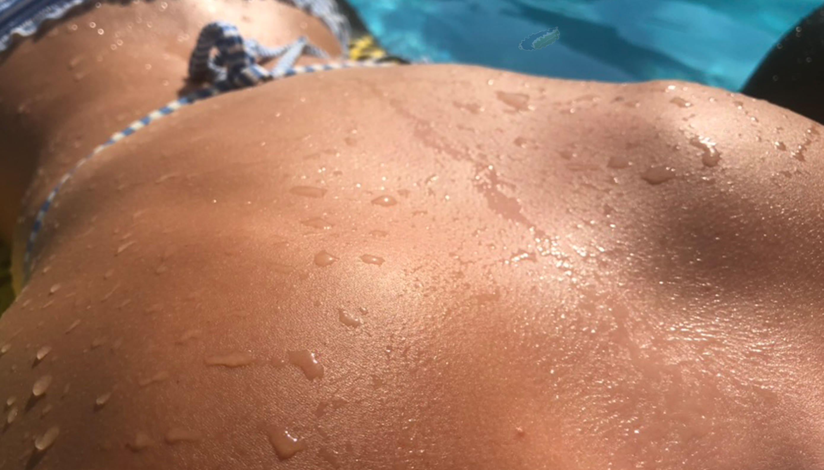 Nahaufnahme nasser Haut in der Sonne am Pool – zeigt UV-Strahlung und die Bedeutung natürlicher Hautpflege im Sommer.